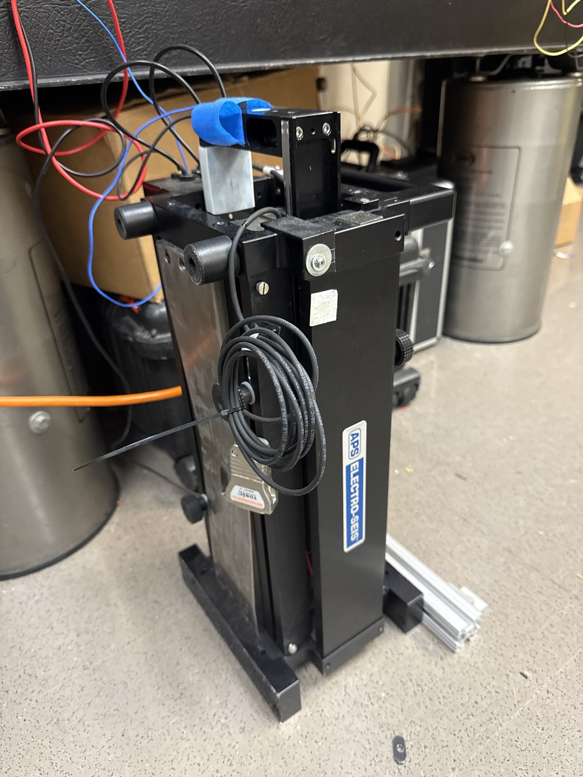 APS electrodynamic shaker mounted vertically on a lab frame.